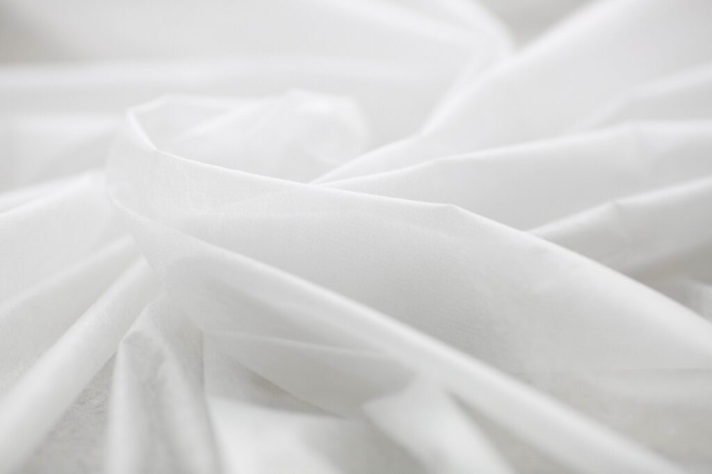 Close-up of white SSMMS nonwoven fabric showcasing its soft texture and layered structure.