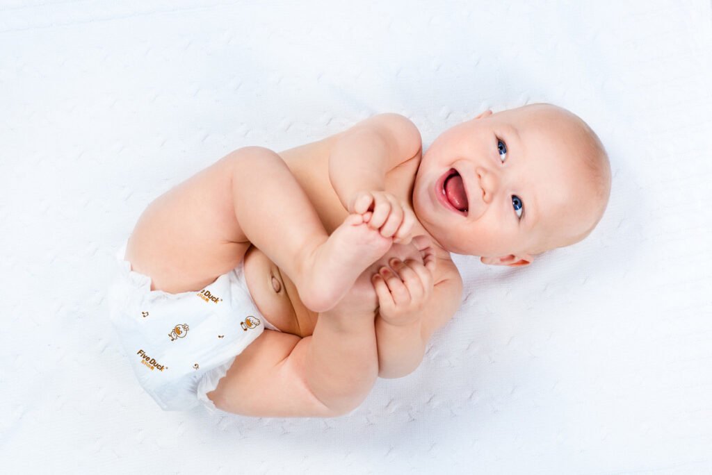 Smiling baby wearing a soft and comfortable diaper by Sanveran